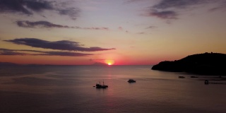 在印度尼西亚巴厘岛附近的弗洛雷斯岛，一架向前飞行的无人机正在拍摄海上日落的奇异空中景色。拍摄分辨率为4k