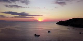 在印度尼西亚巴厘岛附近的弗洛雷斯岛，海上日落的空中美景和船只的剪影。拍摄分辨率为4k