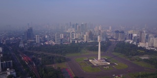鸟瞰图，国家纪念碑，绿色的公园和摩天大楼，在雾蒙蒙的早晨，印度尼西亚雅加达。4K分辨率拍摄