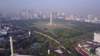 印尼雅加达，国家纪念碑与摩天大楼的鸟瞰图。4K分辨率专业拍摄视频素材模板下载