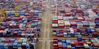 雅加达,印度尼西亚。2017年7月10日:航拍镜头，在丹戎Priok港口码头，起重机和卡车堆叠在一起的货物集装箱。拍摄分辨率为4k