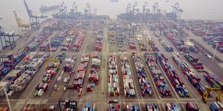 雅加达,印度尼西亚。2017年7月10日:航拍工业港口集装箱码头的吊车、卡车和货船。拍摄分辨率为4k