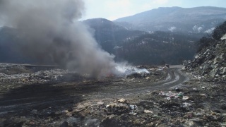 无人机拍摄的大型垃圾填埋场，燃烧的垃圾带着浓重的污染烟雾。视频素材模板下载
