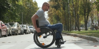 一个坐轮椅的残疾人走在公园的小路上