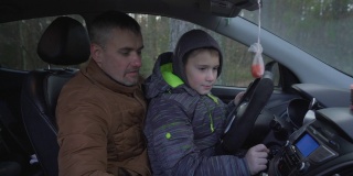 父亲展示并教他的小儿子汽车仪表盘。