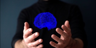 大脑全息图。在人类科学家或用户手中旋转大脑的虚拟3D数字全息图。增强现实，诊断技术，未来科学的概念。