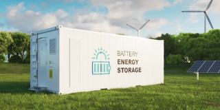 现代高容量电池储能系统的概念，位于郁郁葱葱的草地中央，背景是森林。三维渲染