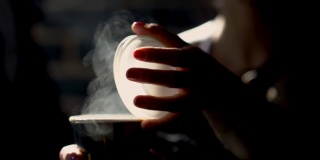 年轻女子正在打开一个热咖啡杯的盖子