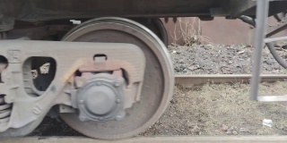 火车靠近照相机。底部部分的火车与车轮和火车轨道的背景。货运列车在铁路上行驶。特写的轮子。