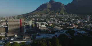 城里建筑物的航拍画面。背景是巨大的岩石山峰。晴朗的天气。南非开普敦
