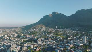 阳光明媚的一天，城市街区的空中全景镜头。背景是落基山脉。南非开普敦视频素材模板下载