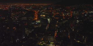 夜城的空中全景拍摄。在市区的建筑物上飞行。南非开普敦