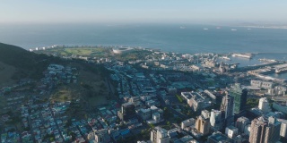 空中全景镜头的各种建筑物在城市附近的海滨。城市中心的高层建筑。南非开普敦