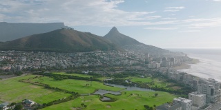在海边开发之间的高尔夫球场上，在茂盛的绿色草坪上飞翔。背景是又高又平的山脊。南非开普敦