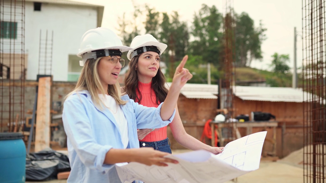 两个女工程师在建筑工地检查图纸