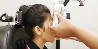 一名年轻女子在眼科诊所用透视仪检查她的眼睛