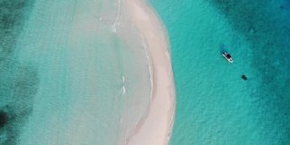 无人机在热带沙洲上空飞行，那里有绿松石和蓝色的海水，珊瑚，一些船和白色的沙子。鸟瞰印度洋上风景如画的岛屿，马尔代夫，拉杜赫，阿利夫阿利夫环礁。