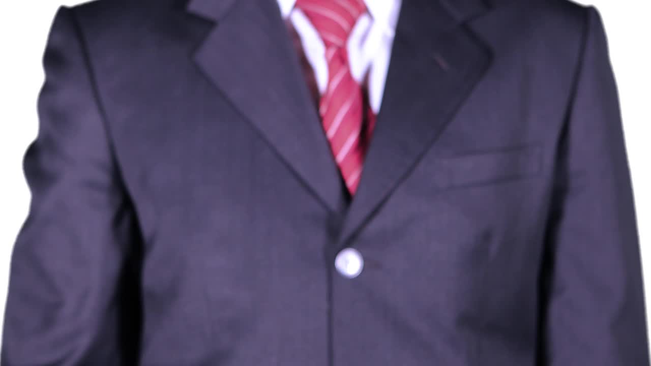 视频画面显示，一名男性企业家从西装口袋里拿着一把老式钥匙，背景是白色的