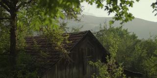 森林中古老舒适的村庄木屋的屋顶，背景是群山。城里的房子。农村