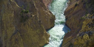 美丽的绿色河流水冲过岩石山脉在峡谷中一个小水池，然后超越。