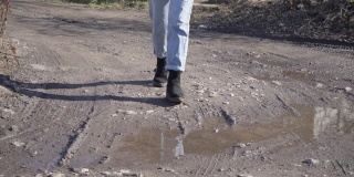 穿牛仔裤的女孩走在泥泞中慢动作