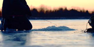 冬天，人们在结冰的湖面上钓鱼，捕鱼