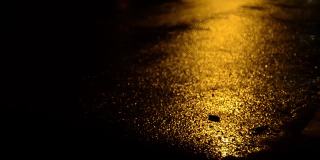 午夜时分，汽车的前灯映照在潮湿的柏油路上