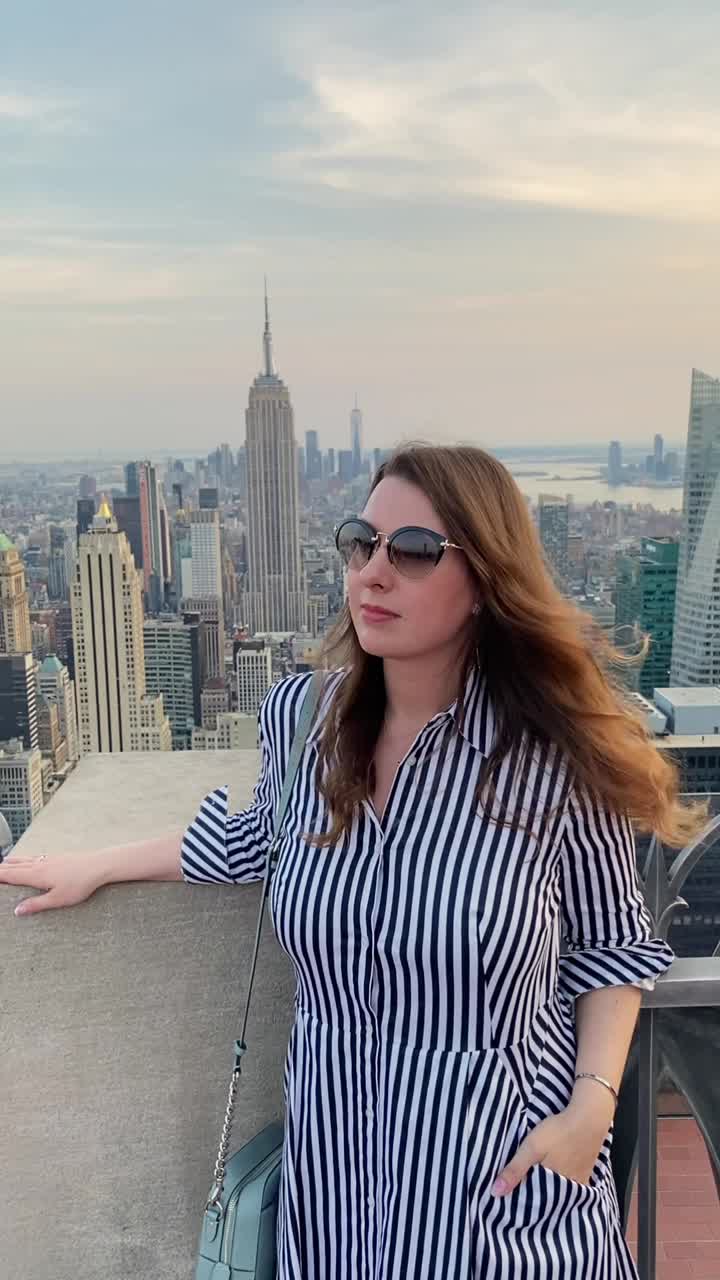 屋顶上的女孩俯瞰纽约市，日落时分曼哈顿的全景