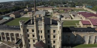 鸟瞰废弃的古老的Joliet监狱，这是一个历史遗迹。无人机向后飞行，捕捉位置的全景。伊利诺斯州内伯维尔大街和乔利埃特监狱。