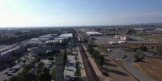 鸟瞰图，加州欧文郊区的大型工业区，有铁路和火车经过。水平平移，慢动作。