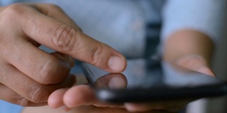 近距离观察一名女子的手指，她正在移动应用程序上滚动智能手机触摸屏上的在线购物项目。