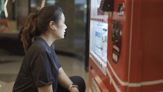美丽饥饿的女人在自动贩卖机里买东西视频素材模板下载