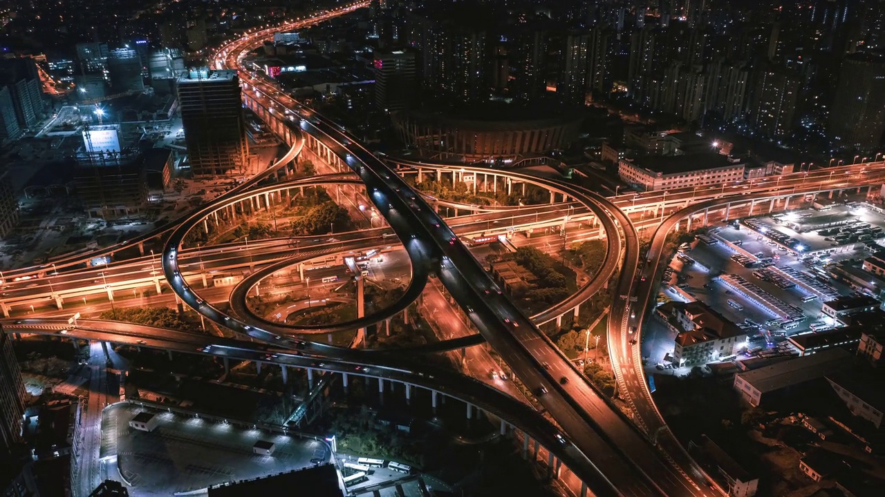 高速公路十字路口和上海市区空中立交桥夜景。巨大的道路交叉口，从上面可以看到繁忙的交通。