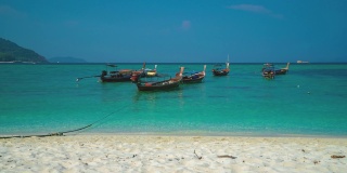 美丽的Cinemagraph无缝视频循环传统长尾船在遥远的热带亚洲海滨沙滩Perhentian岛，马来西亚充满活力的全景海景。蓝天碧水，风景秀丽，是旅游度假区