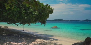 美丽的Cinemagraph /无缝视频循环在遥远的热带亚洲海滨沙滩在Perhentian岛，马来西亚一个巨大的树和充满活力的全景海景秋千。蓝天碧水，风景秀丽，是旅游度假区。
