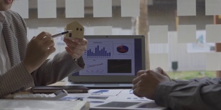 亚洲商人在办公室做财务会计工作，用笔记本电脑和图形文件对商业概念表进行计算分析。