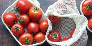 新鲜的西红柿放在可重复使用的购物袋里放在桌子上