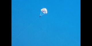 滑翔伞是一种活跃的休闲方式，人用长缆绳固定到船上
