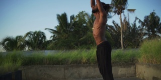 男子练习高温瑜伽合十礼姿势屋顶太阳能电池快速慢动作
