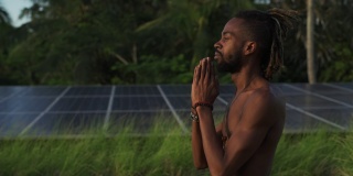 黑人男子做高温瑜伽合十礼式屋顶太阳能电池快速慢动作