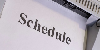 日程表，办公室打印机打印在一张白纸上，特写，俯视图，为日程表列表的启动屏幕布局。