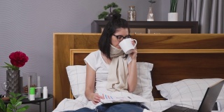 相当沮丧疲惫忙碌的妇女在流感期间在家治疗，一边喝茶一边浏览不同的报告，远程工作