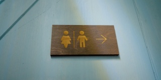 墙上有男厕所和女厕所的标志。性别分工