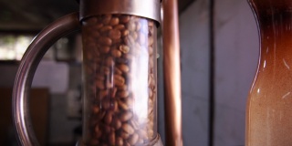 新鲜烘焙的咖啡豆在流体床烘烤咖啡机。小型咖啡工业企业。