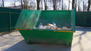 城市街道上的大型绿色金属垃圾箱，里面有建筑垃圾。视频素材模板下载