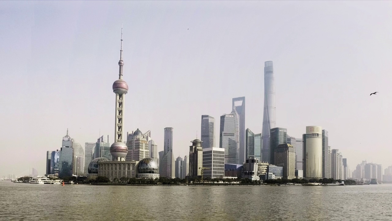 在上海的天际线上，货船和船只在黄浦江上穿梭