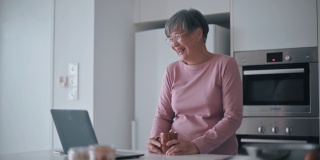 亚裔华裔女性在周末闲暇时间用笔记本电脑给朋友打电话