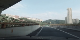 在城市高架桥下的高速公路上，从汽车上向外望去