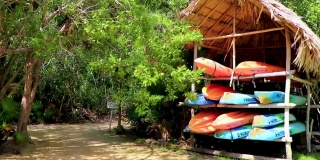 橙、红、蓝独木舟在墨西哥的Muyil泻湖游船