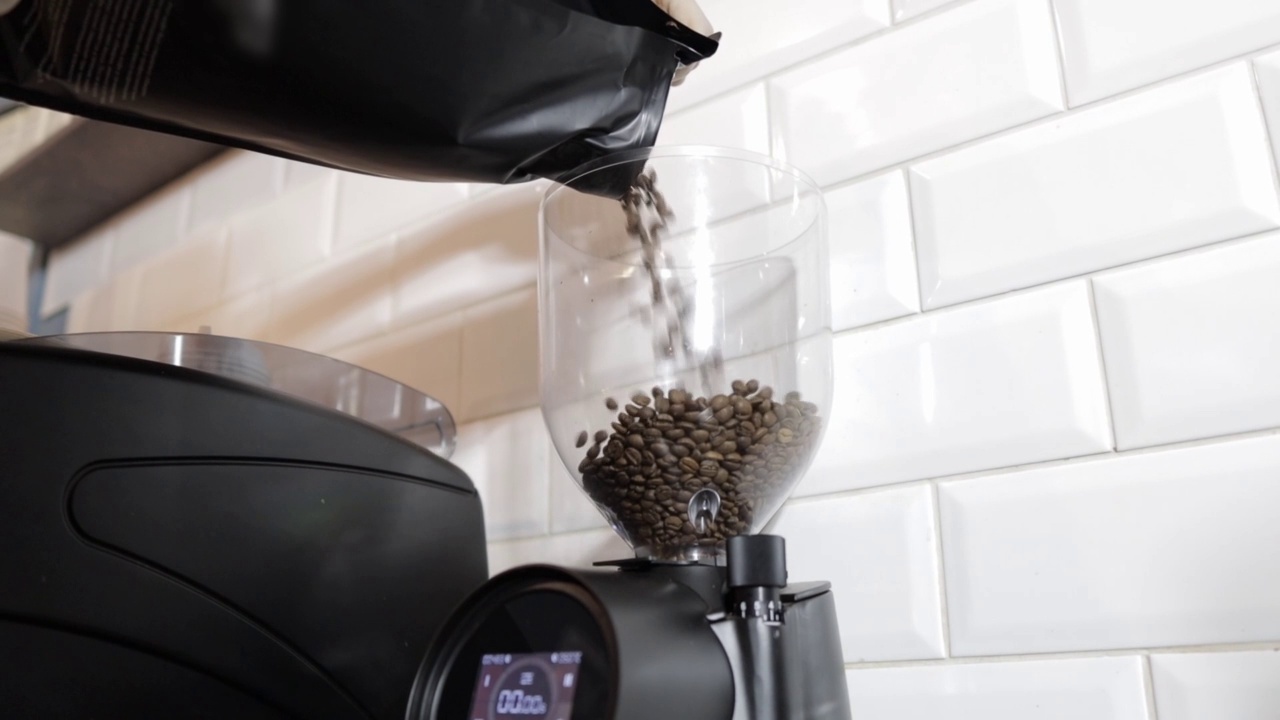 咖啡师会用专业的咖啡研磨机给咖啡豆喂食
